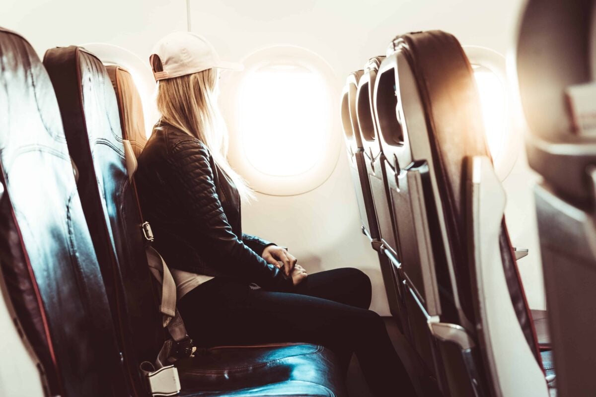 woman on plane seat looking out window.