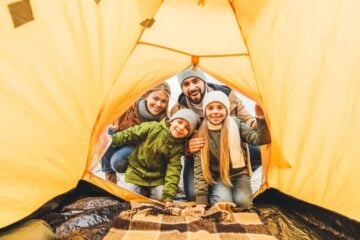 family dressed in warm clothes looking into tent
