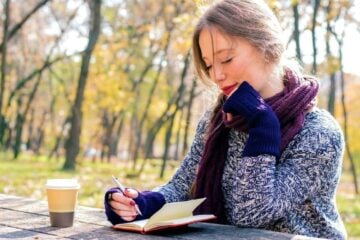woman writing in travel journal